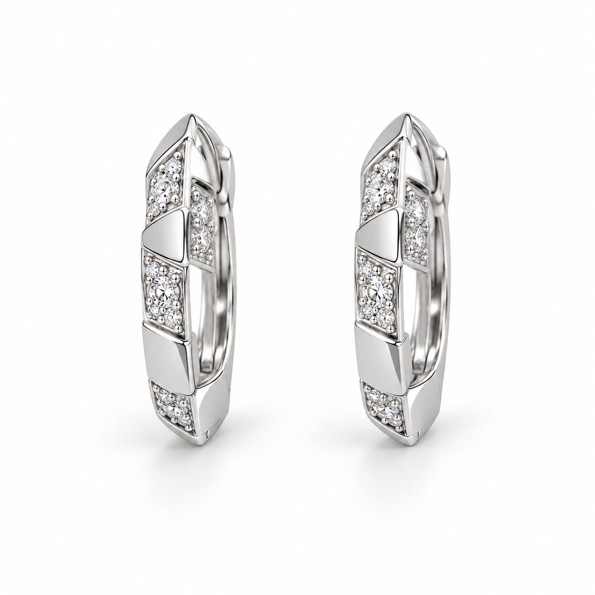 Faceted silver-tone hoop earrings with alternating polished segments and white-stone panels on a white background.